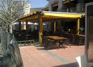 Pergola fitted with roller blinds yellow